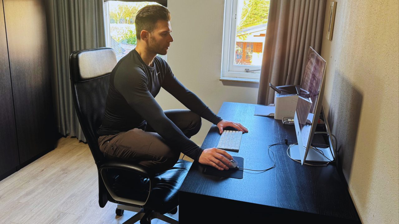 De rustsquat op de bureaustoel: bilspieren, benen en wervelkolom actief.